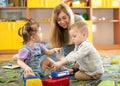 Babysitter plays with babies in nursery Royalty Free Stock Photo