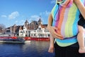 Babywearing or motherhood concept with young mother carrying her baby in Amsterdam