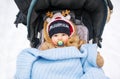 Babywith a pacifier in a perambulator at a winter day. Royalty Free Stock Photo