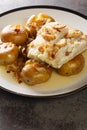 Bacalhau a Lagareiro Grilled Salted Cod with Olive Oil served with baked Potatoes closeup in the plate. Vertical Royalty Free Stock Photo