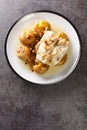 Bacalhau a Lagareiro Grilled Salted Cod with Olive Oil served with baked Potatoes closeup in the plate. Vertical top view Royalty Free Stock Photo