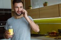 Bachelor man daily routine in a kitchen single lifestyle concept phone call drinking juice Royalty Free Stock Photo