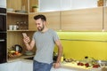 Bachelor man daily routine in the kitchen single lifestyle concept with phone smiling Royalty Free Stock Photo