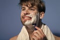 Bachelor smile with shaving cream, razor and towel