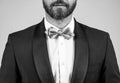 Bachelor with unshaven face cropped view wear elegant tuxedo with silver bow tie grey background, formal