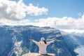 Back of adventurous sportive girl hiker with open arms sitting a