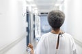 Back of african american senior female patient with drip walking in hospital corridor Royalty Free Stock Photo