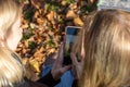 Back ant top view of two young women looking at photo in smart phone Royalty Free Stock Photo