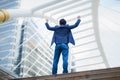 Back of Asian businessman stand and raising up his hands to celebrated his successful in career and mission.