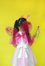 Back of asian girl dressed in fairy costume isolated on yellow background Royalty Free Stock Photo