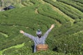 Back of asian hill tribe woman ethnic minority with traditional clothes standing raised up arms celebrate in tea plantation