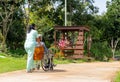 Back of Asian nurse cart of shove senior man sit on wheelchair to walk along the walkway in the garden and they look happiness Royalty Free Stock Photo