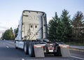 Back of big rig semi truck tractor with high cab for long haul freights running on the highway road to warehouse for pick up Royalty Free Stock Photo