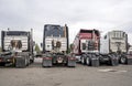 Back of big rigs semi trucks standing in row on truck stop parking lot Royalty Free Stock Photo