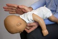 Back blows the Heimlich maneuver or Heimlich manoeuvre on a simulation mannequin infant dummy during medical training Basic Life