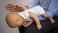 Back blows the Heimlich maneuver or Heimlich manoeuvre on a simulation mannequin infant dummy during medical training Basic Life