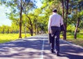 Back body Businessman walking on road in park. Royalty Free Stock Photo