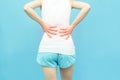 Back body of the woman put her hands on back or waist area mark red at spot of ache, backpain Health-care concept isolated on blue Royalty Free Stock Photo