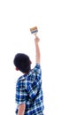 Back of boy holding brush in his hand on white.