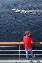 Back of boy standing at railing on deck of ship Royalty Free Stock Photo