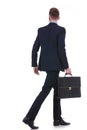 Back of a business man with suitcase walking away