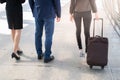 Back of businessman and businesswoman walk together with luggage on the public street, Royalty Free Stock Photo