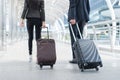 Back of businessman and businesswoman walk together with luggage on the public street, business travel concept Royalty Free Stock Photo