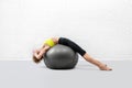 Back and chest stretching with exercise ball. Slim caucasian woman in sportswear lying down on fitball and relaxes Royalty Free Stock Photo