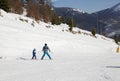 back of a child and an adult in warm overalls, on skis. skiing lesson on a snowy slope in the mountains Royalty Free Stock Photo