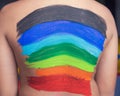 Back of a child painted with rainbow