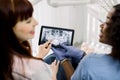 Back close up cropped image of female african dentist and caucasian woman patient at dentist`s office, holding together