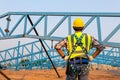 The back of construction worker wearing safety harness and safety line working at high place on roof in construction site Royalty Free Stock Photo