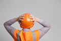 Back of contruction worker clutching head in helmet on grey studio background looking, foreman shocked Royalty Free Stock Photo