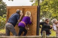 Back of a couple posing with heads in face in head board at wine festival while two friends check the pictures they `ve just taken