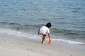 Back of a cute little girl playing with sand on a beach Royalty Free Stock Photo