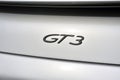 Back detail on the GT3 logo of a sports car Gray porsche on a par