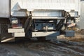 The back of a dirty gray truck with a black iron bumper