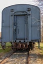 Back door of an old abandoned blue gray railroad train car showing the coupling hook and track. Royalty Free Stock Photo