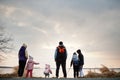 Back of family with four kids on the shore of the lake Royalty Free Stock Photo