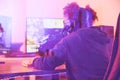 Back of girl, gamer and computer in home, desk or online games of virtual competition. Female streamer, live streaming