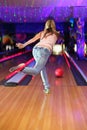 Back of girl making throw of ball in bowling club