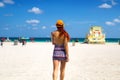 Back of the girl at Miami beach Florida Atlantic Ocean,Young woman in cool printed mini dress is walking on paradise sandy beach Royalty Free Stock Photo