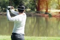 Back of golf Player in white shirt swinging glof. Young man practicing his swing on the golf course Royalty Free Stock Photo