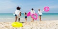 Back of group of teenage girls hold swimming ring and ball also run to the sea and they look happy and enjoy for holiday or Royalty Free Stock Photo