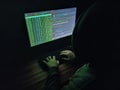 Hacker in the shadows, typing in the dark