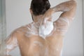 Back of handsome athletic wet young man taking shower Royalty Free Stock Photo