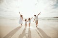 Back of happy caucasian parents with daughters enjoying free time on a beach. Little girls bonding with their mother and Royalty Free Stock Photo