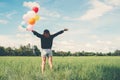 Back of happy young woman standing on green field enjoy with fresh air. Royalty Free Stock Photo