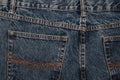 Back of jeans. classic blue jeans back pockets. Classic jeans with five pockets close-up. Rough blue textured denim. trendy casual