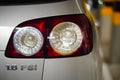 Back lamp of a parked silver colored Volkswagen Golf Plus in a parking